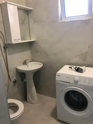 a bathroom with a washing machine and a sink at Rejhan TOTTI in Ulcinj