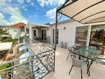 a patio with a table and chairs on a balcony at Rejhan TOTTI in Ulcinj