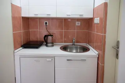 a small kitchen with a sink in a room at Apartmani Novkovic in Bar