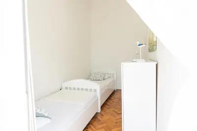 a white room with two beds and a mirror at Apartmani Novkovic in Bar
