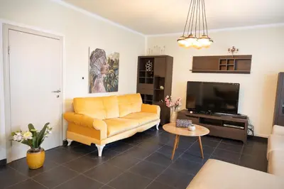 a living room with a yellow couch and a tv at Apartmani Novkovic in Bar