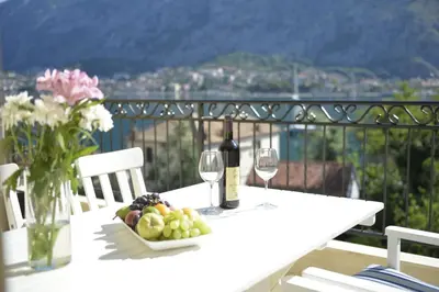a white table with a plate of fruit and wine glasses at Posto Capitano C Group in Kotor