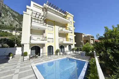 a building with a swimming pool in front of it at Posto Capitano C Group in Kotor
