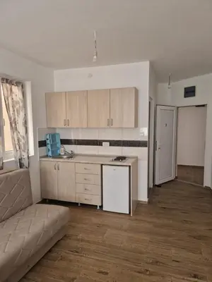 an empty living room with a kitchen and a couch at Apartmani Sijaric in Dobra Voda