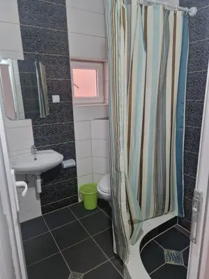 a bathroom with a shower curtain and a sink at Apartmani Sijaric in Dobra Voda