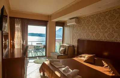 a bedroom with a bed and a view of the water at Hotel Velkom in Sutomore