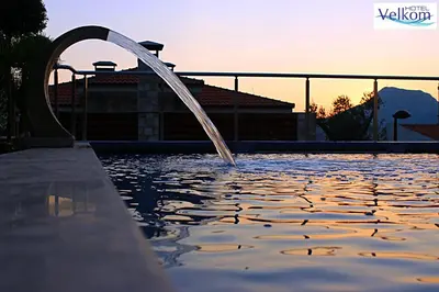 a pool with a water fountain in the middle at Hotel Velkom in Sutomore