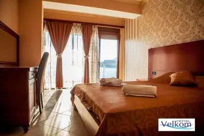 a bedroom with a large bed with a large window at Hotel Velkom in Sutomore