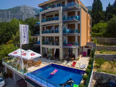 an apartment building with a swimming pool and a hotel at Hotel Velkom in Sutomore