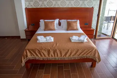 a bedroom with a bed with two towels on it at Hotel Velkom in Sutomore