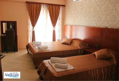 a hotel room with two beds and a window at Hotel Velkom in Sutomore