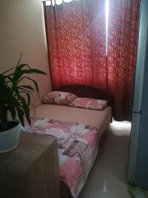 a small bed in a room with a red curtain at Apartments Vis Jaz in Budva