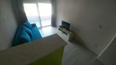 a living room with a blue couch and a television at Apartman Bećir in Budva