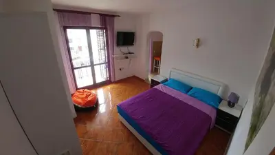 a small bedroom with a bed and a window at Apartman Bećir in Budva