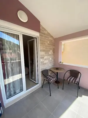 a balcony with a table and chairs and a window at Apartmani Raskovic in Budva