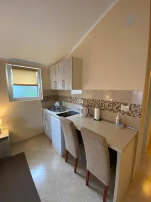 a kitchen with a table and some chairs in it at Apartmani Raskovic in Budva