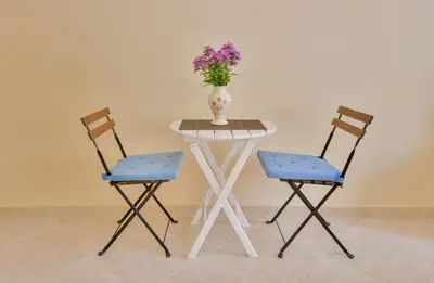 a table with two chairs and a vase with flowers on it at Apartmani Raskovic in Budva