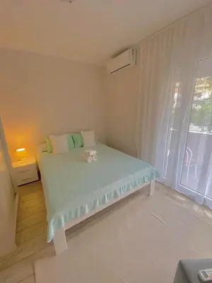 a small room with a bed with a window at Apartmani Raskovic in Budva