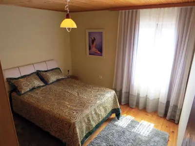 a bedroom with a bed and a large window at Estate & Winery San Duyevo in Rijeka Crnojevića