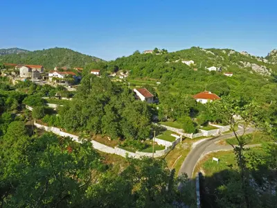a small village on a hill with a road at Estate & Winery San Duyevo in Rijeka Crnojevića