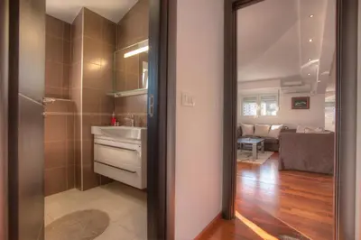 a small bathroom with a sink and a mirror at Apartment Mitrovic in Budva