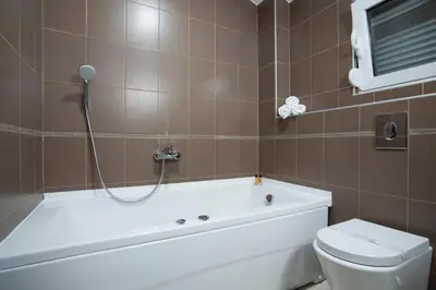 a bathroom with a tub and a toilet and a shower at Apartment Mitrovic in Budva