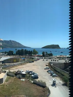 a group of cars parked in a parking lot next to the water at Apartment Seaview Budva in Budva
