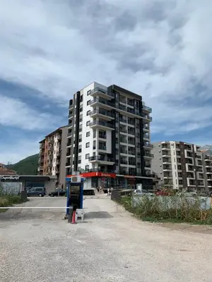 a tall apartment building in a parking lot at Apartment Seaview Budva in Budva