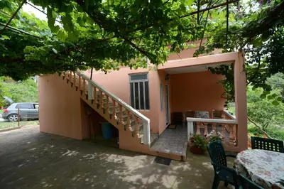 a small house with a staircase in front of it at President Holiday home in Utjeha