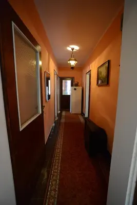a hallway of a house with a door and a refrigerator at President Holiday home in Utjeha