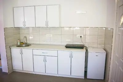 a kitchen with white cabinets and a sink and a refrigerator at Apartments Leyla in Ulcinj