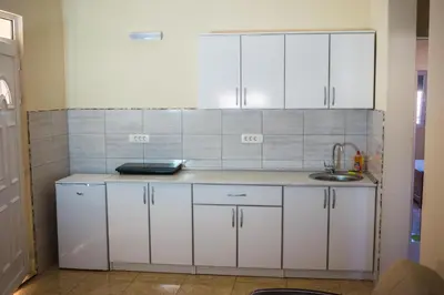 a kitchen with white cabinets and a sink at Apartments Leyla in Ulcinj