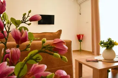a living room with a couch and a table with flowers at Beach Walk Apartments in Ulcinj