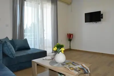 a living room with a blue couch and a table at Beach Walk Apartments in Ulcinj