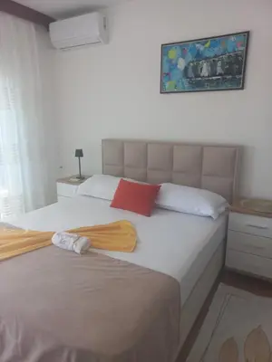 a bedroom with two beds and a painting on the wall at Apartments Gazi in Ulcinj