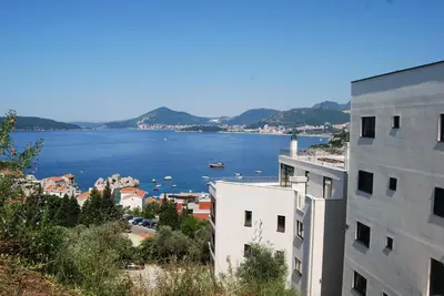 a view of a body of water between two buildings at Apartment Divina in Sveti Stefan