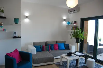 a living room with a couch with colorful pillows at Apartment Divina in Sveti Stefan