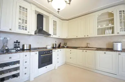 a white kitchen with white cabinets and a sink at Villa St.George in Petrovac na Moru