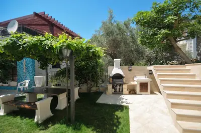 a backyard with a table and a pizza oven at Villa St.George in Petrovac na Moru