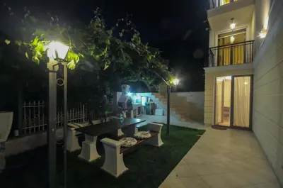 a park bench in the yard of a house at night at Villa St.George in Petrovac na Moru
