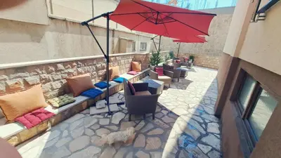 a patio with a red umbrella and some chairs at Apartments Kaladjurdjevic in Budva