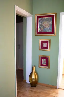 a vase sitting on the floor in a room with paintings at Apartment Dadi in Cetinje