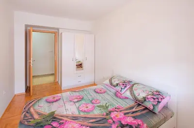 a bedroom with a bed with pink flowers on it at Apartment S&S Budva in Budva