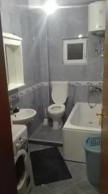 a bathroom with a toilet and a sink and a bath tub at Apartment Panorama Vista 72 in Bar