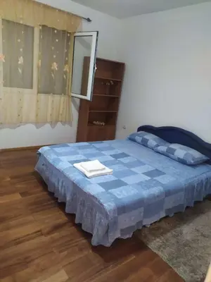 a bedroom with a blue bed with a dresser and a mirror at Apartman Any Bar in Bar