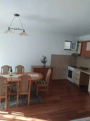 a kitchen and dining room with a table and chairs at Apartman Any Bar in Bar