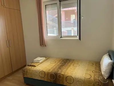 a small bedroom with a bed and a window at Apartman Any Bar in Bar