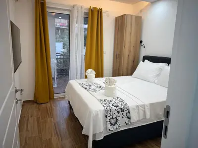 a bedroom with a bed with a table and a window at Eman Resort in Ulcinj