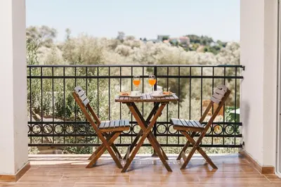a table on a balcony with two glasses of wine at Eman Resort in Ulcinj