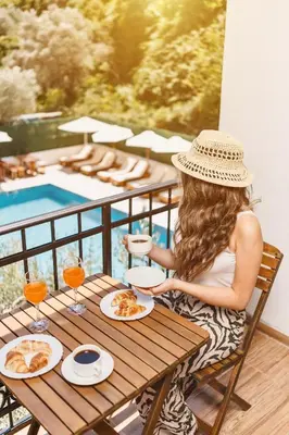a woman sitting at a table with plates of food at Eman Resort in Ulcinj